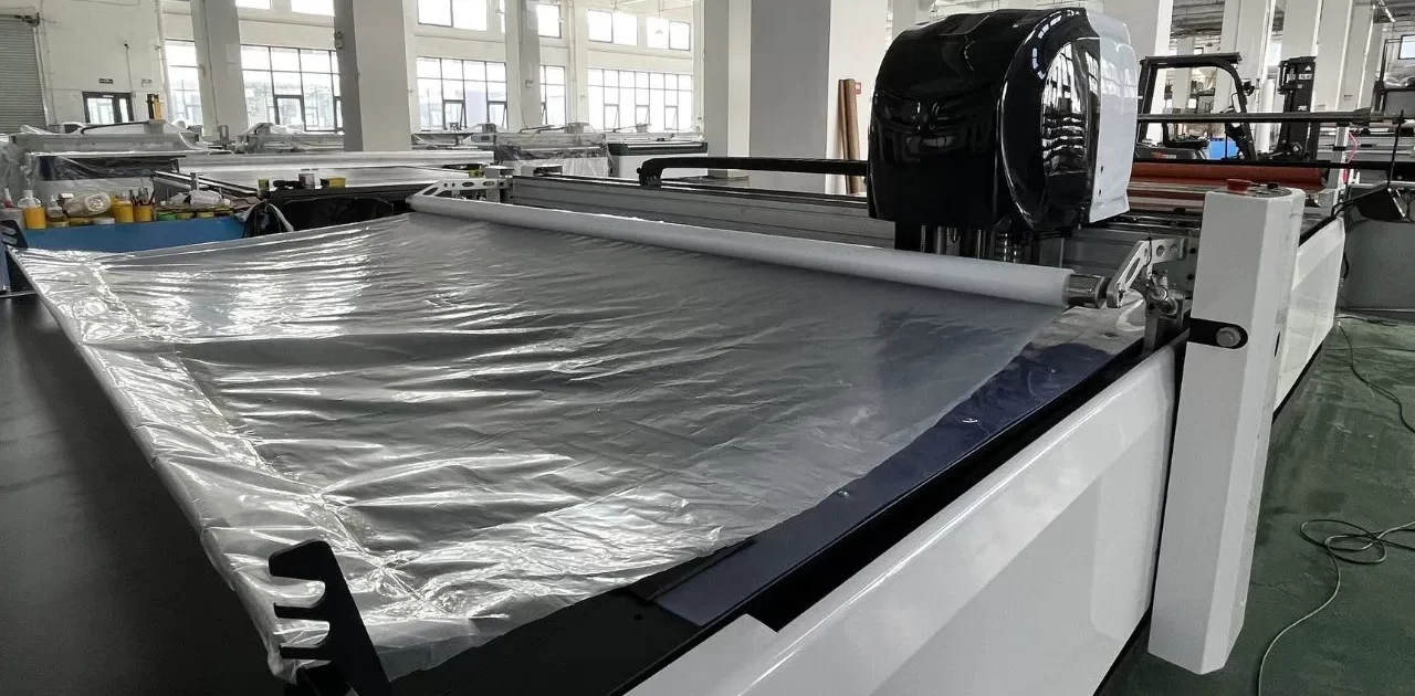 automatic fabric cutting machine plastic film covering fabric 1 1280x630 - MACHINE AUTOMATIQUE DE COUPE DE TISSU