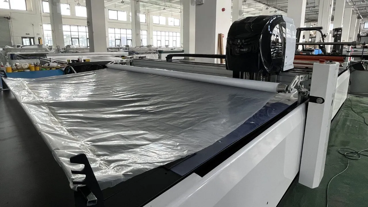 automatic fabric cutting machine plastic film covering fabric - Machine automatique à couper les tissus